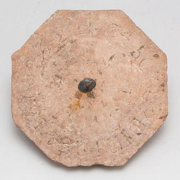 A limestone and iron sundial dated 1732.