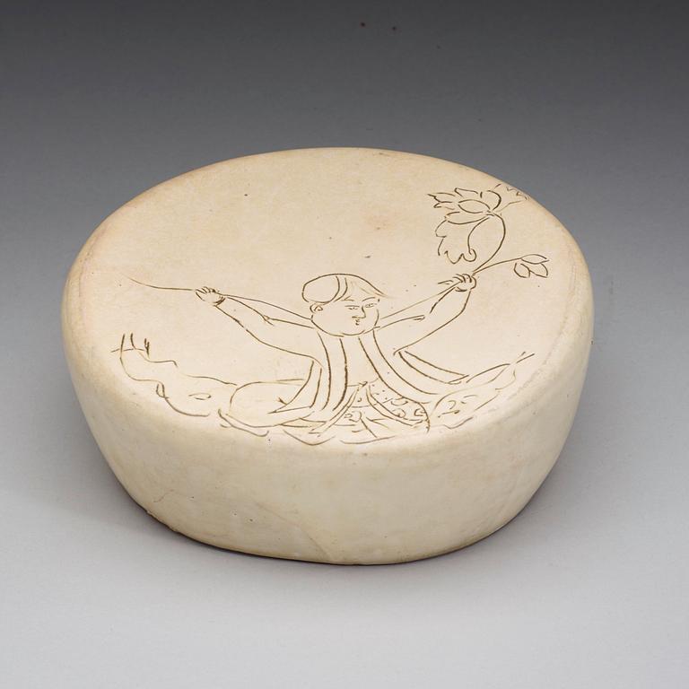 A potted white glazed pillow with incised decor of a boy, presumably Liao or Song Dynasty (907-1279).