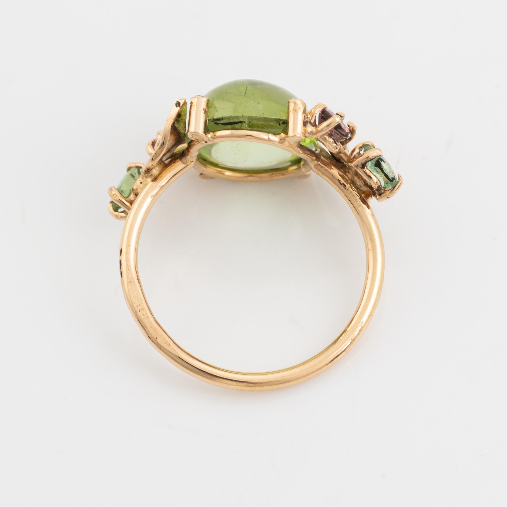 Ring with cabochon-cut peridot, tourmaline, and small diamonds.