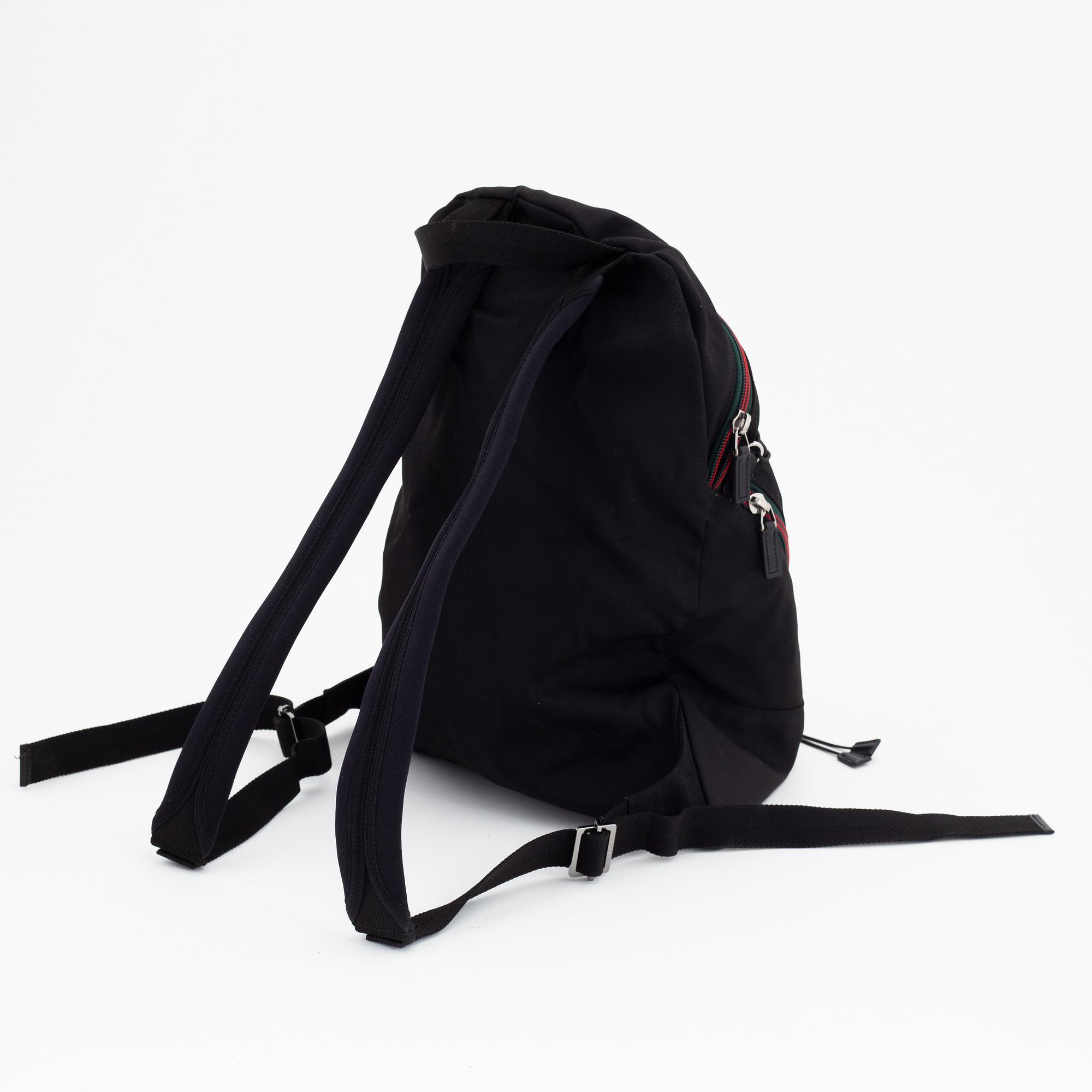 Gucci, a black canvas backpack.