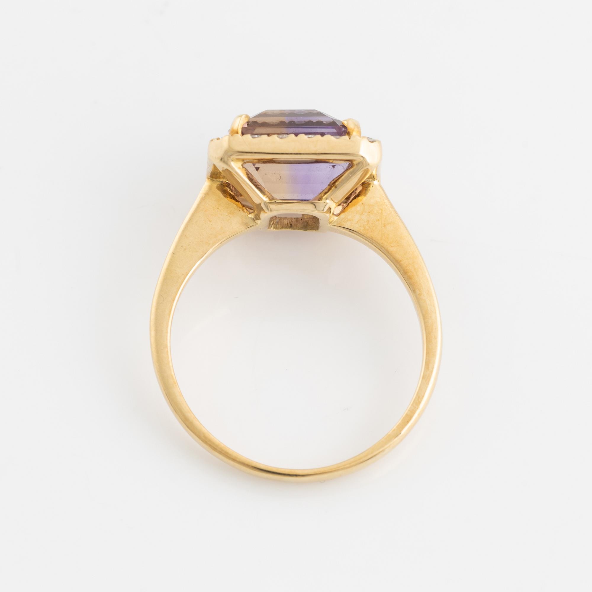 An 18K gold and ametrine ring set with round brilliant-cut diamonds.