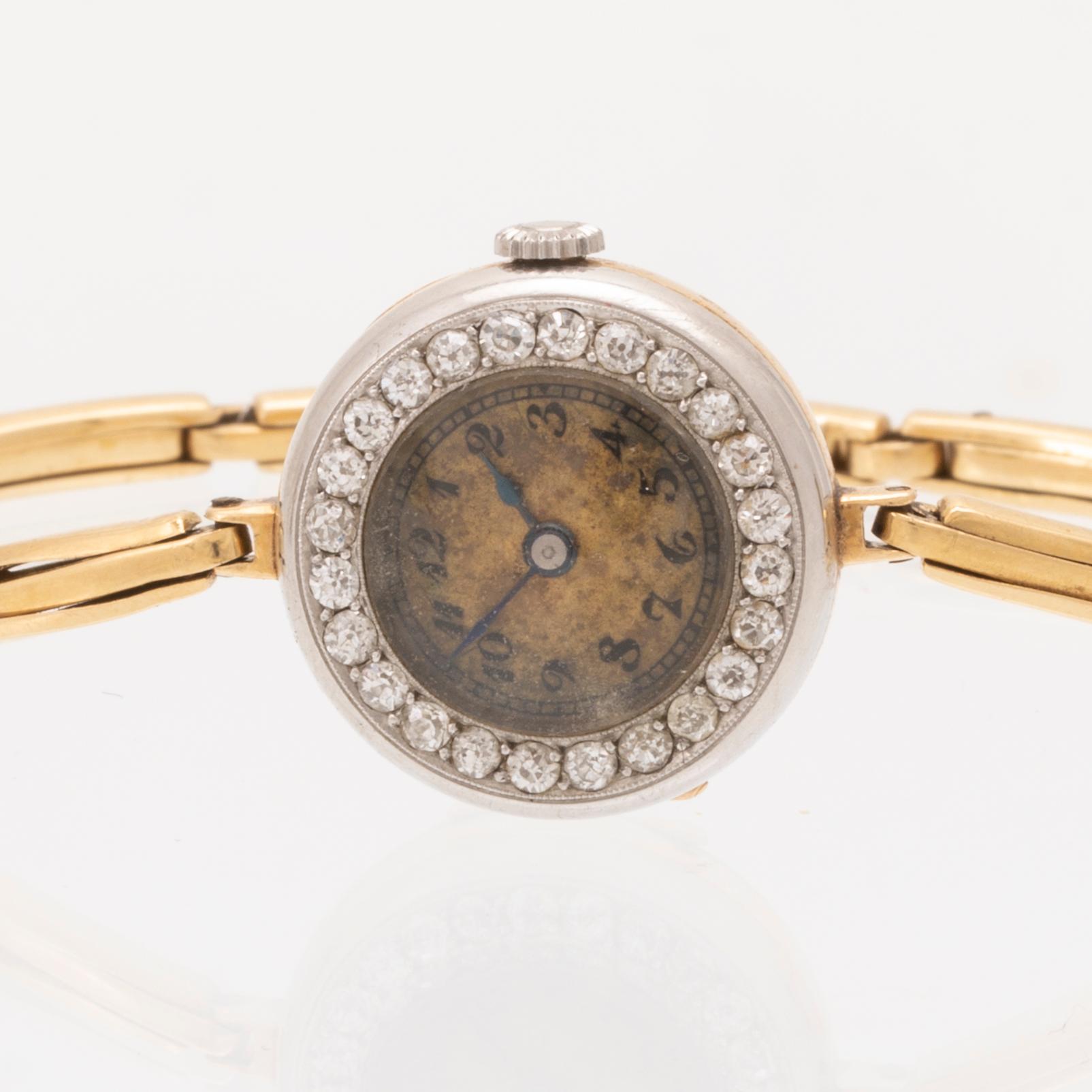 An 18K white and red gold watch set with round old cut diamonds.