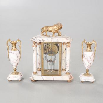 A Louis XVI style table clock and two urns, around the year 1900.