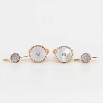 A pair of cufflinks and a pair of shirt buttons.