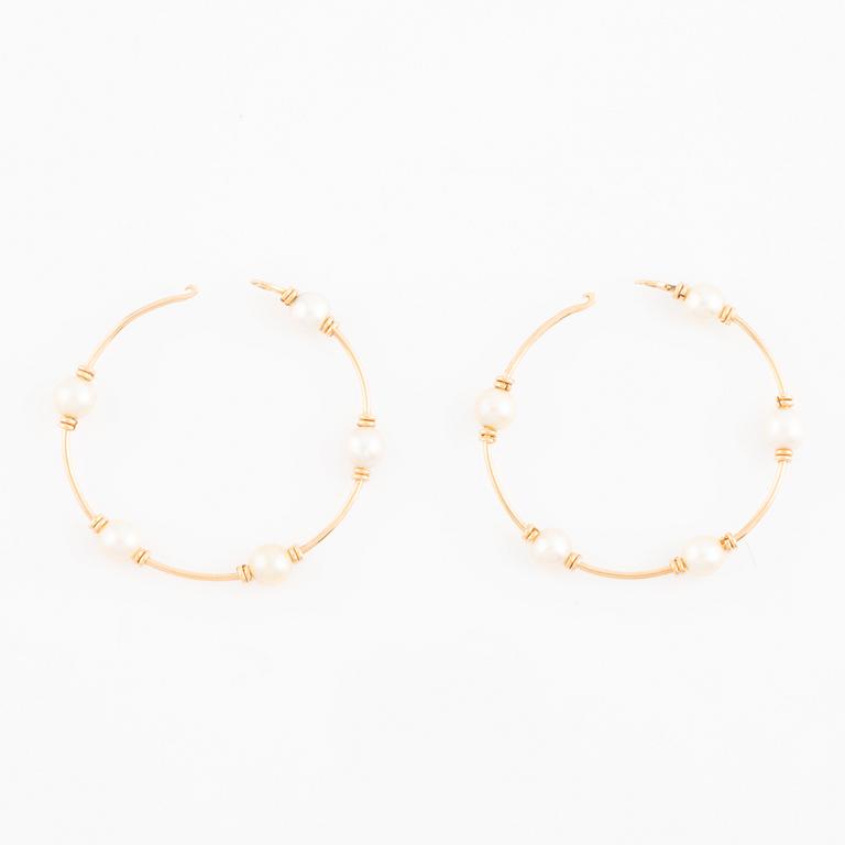 Gold and pearl hoop earrings.