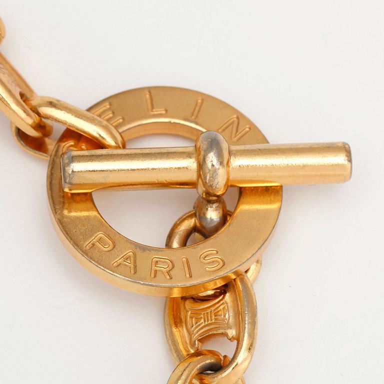 CÉLINE, a gold colored chain / necklace.
