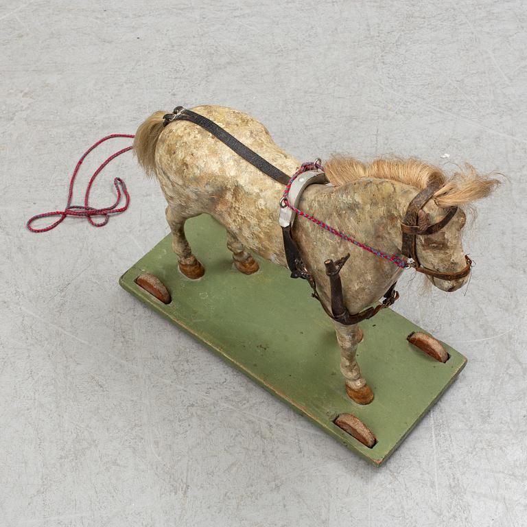 A painted early 20th century toy horse on wheels.