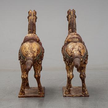 A pair of large Chinese wooden and gilt sculpture of horses, first half of the 20th century.