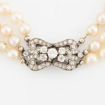 A three-strand cultured pearl necklace with an 18K white gold clasp with round brilliant-cut diamonds.