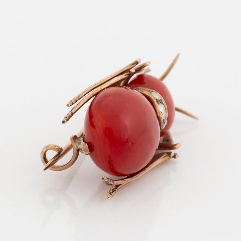 A coral brooch set with pearls and pink sapphires.