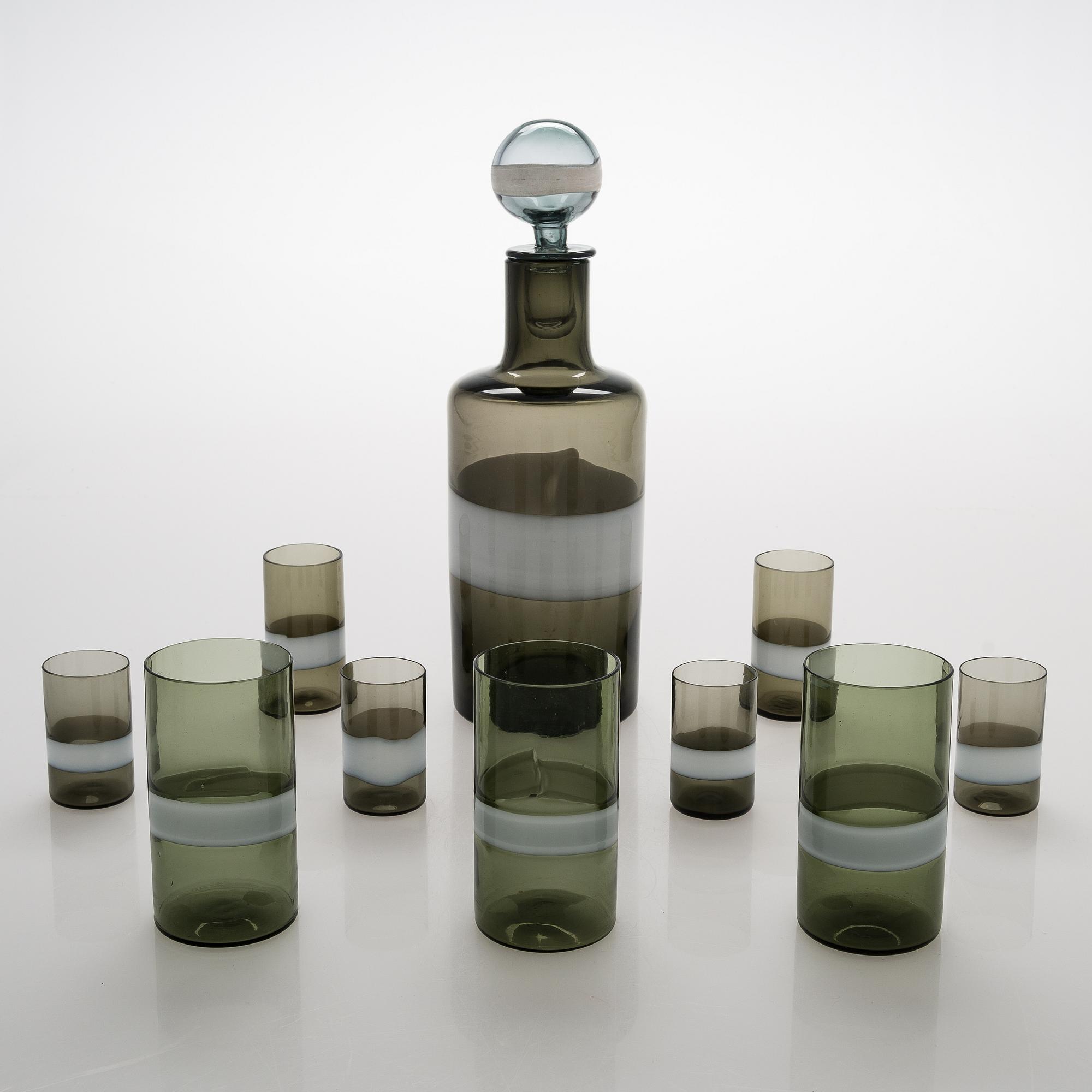 A glass carafe with 9 drinking glasses. The carafe signed Venini, Murano ITALIA.