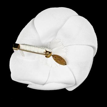 A white camelia brooch by Chanel.