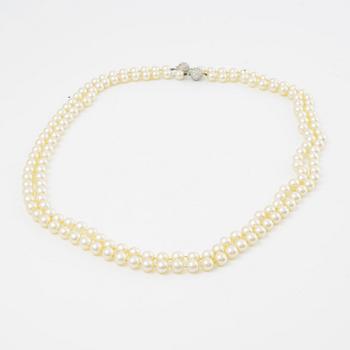 Two necklaces of cultured pearls clasp set with round brilliant-cut diamonds, 18K gold.