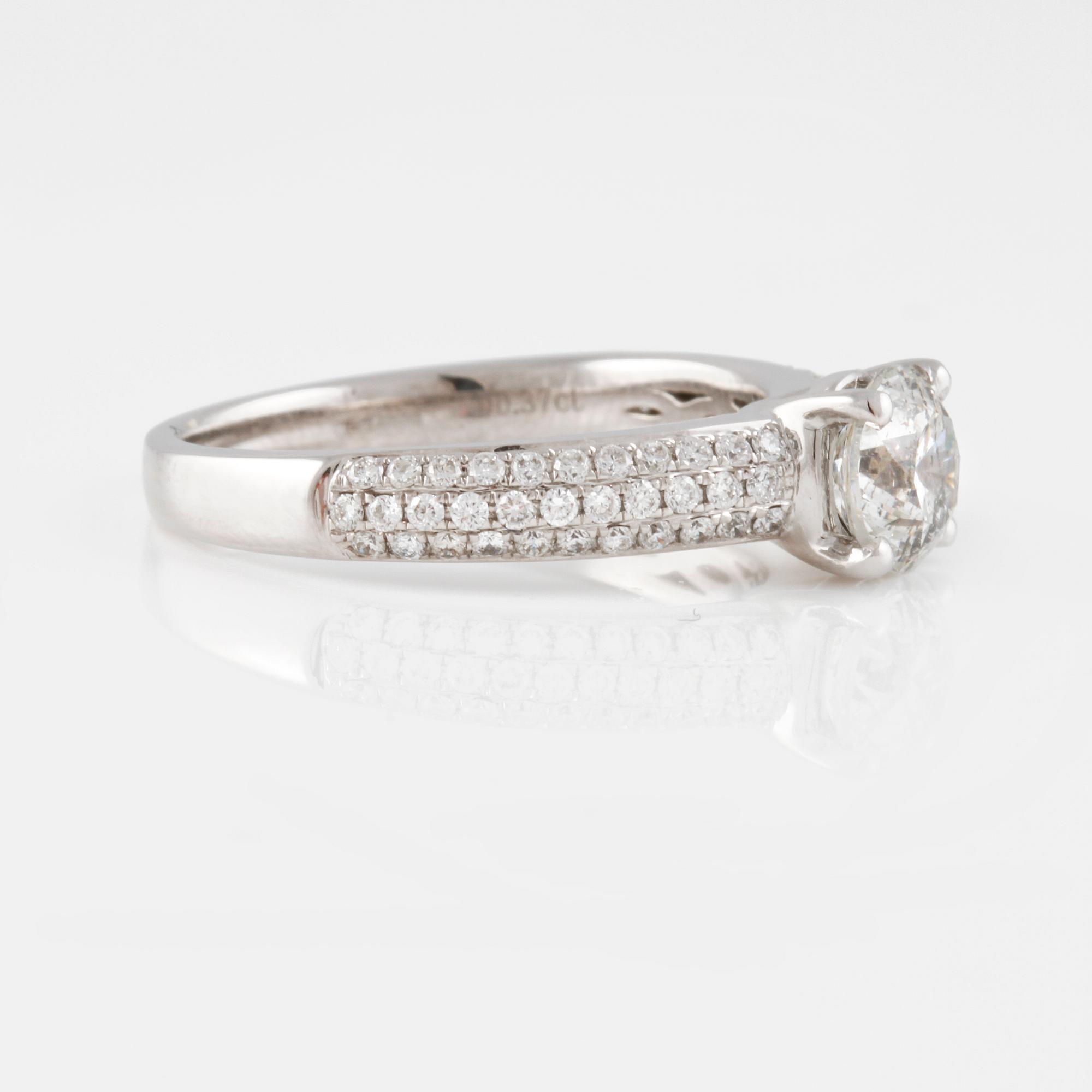 RING, 18K vitguld med briljantslipad diamant ca 1.01 ct samt små diamanter ca 0.37 ct. Vikt 4,3 gram.
