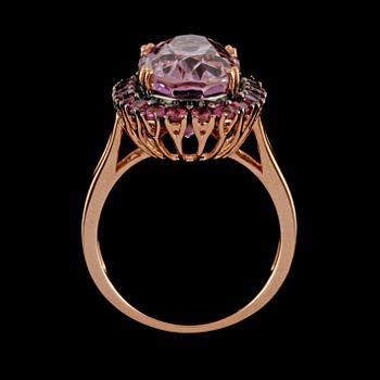 RING, 18K guld med ovalslipad rosa kunzit 9.41 ct samt fasettslipade granater 1.15 ct. Vikt 6,9 gram.