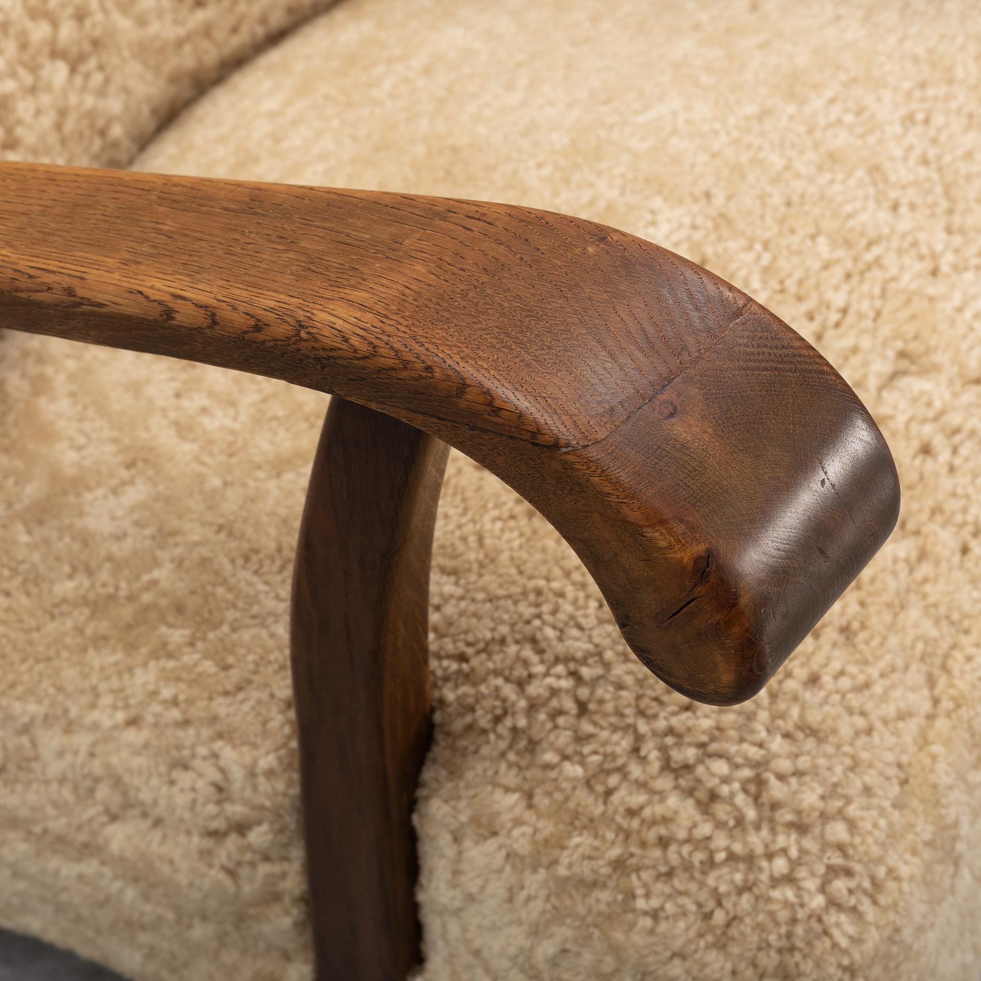 A pair of Danish lounge chairs with sheepskin upholstery.
