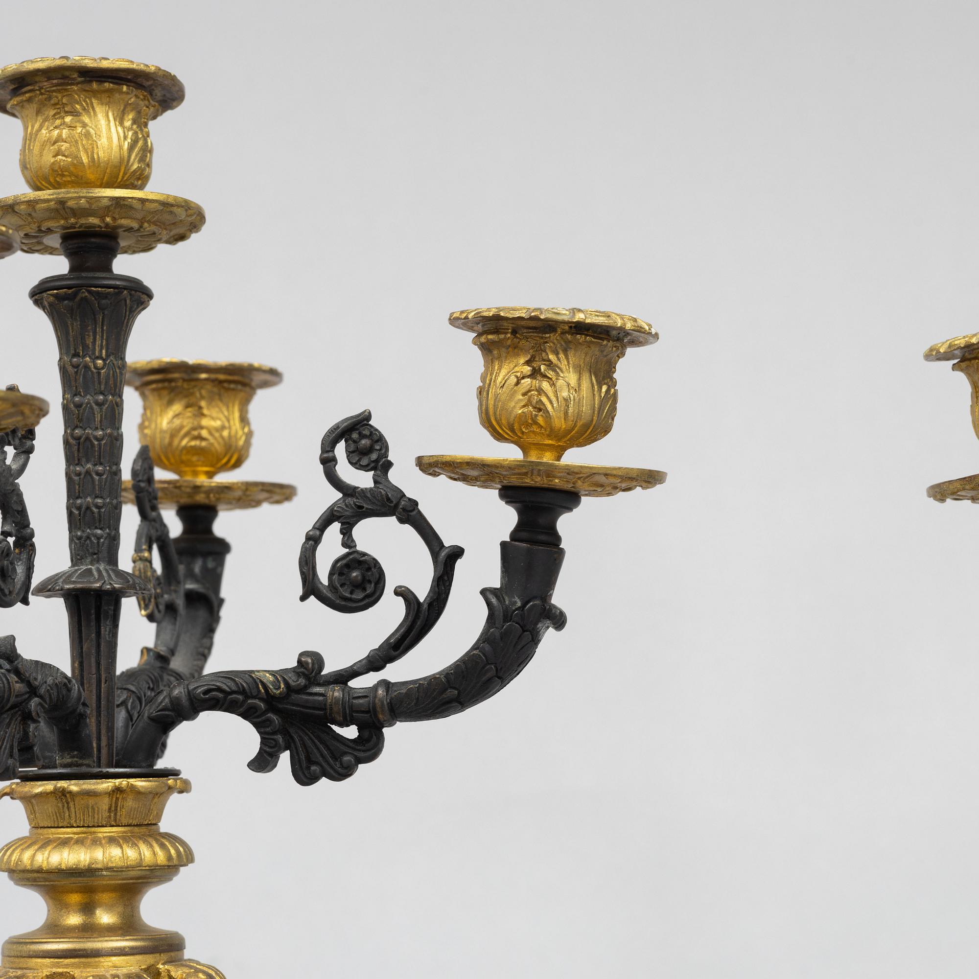 A pair of French Empire-style patinated and gilt bronze five-light candelabra, later part 19th century.