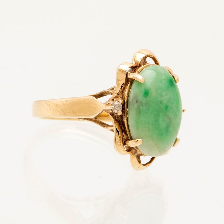 Ring in 14K gold with a green oval cabochon-cut stone and round brilliant-cut diamonds.