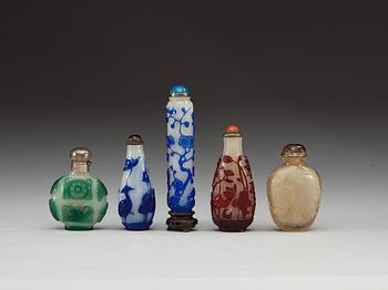A set of five red, blue and green overlay glass snuff bottles, and one in rock crystal, late Qing dynasty (1644-1912).