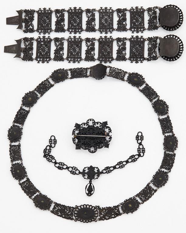 A Berlin steel and iron parure comprising a necklace, two bracelets and a brooch.