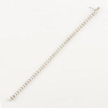 An 18K white gold tennis bracelet set with round brilliant-cut diamonds.