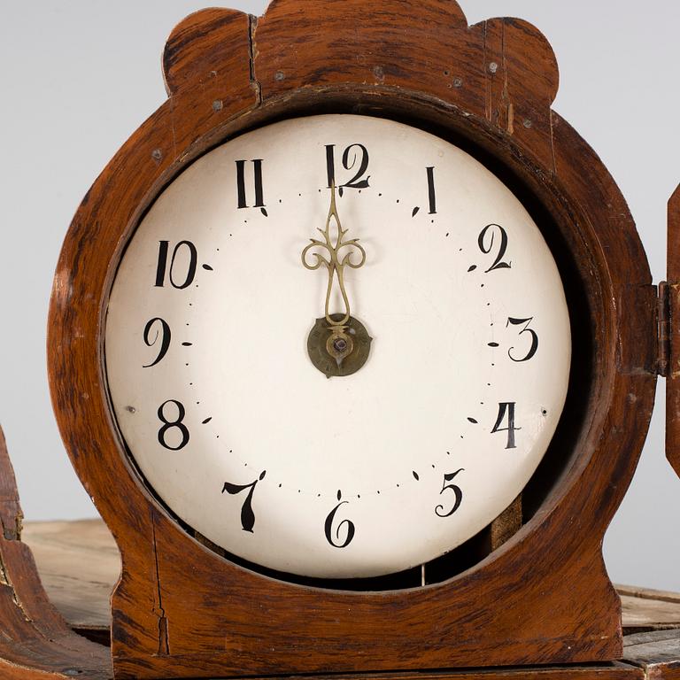 An 18th century cabinet with a clock.
