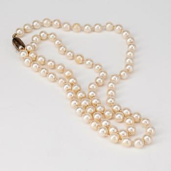 CÉLINE, a decorative white pearl necklace.