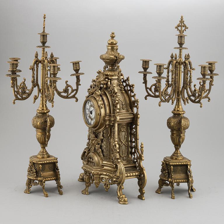 A 20th Century set of a brass mantle clock and a pair of candelabras.