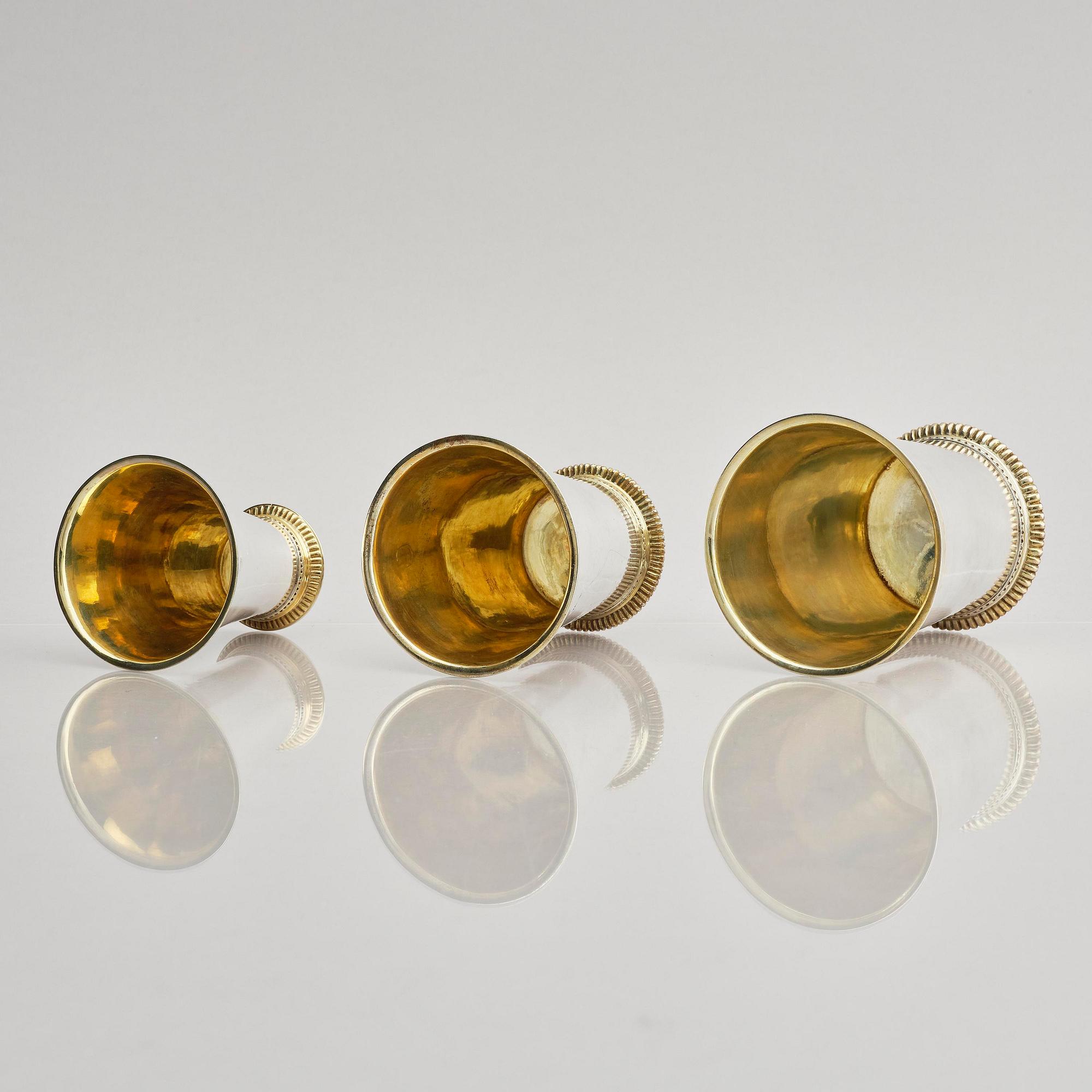 Three Swedish 18th century parcel-gilt silver beakers and a case of birch, different maker's.