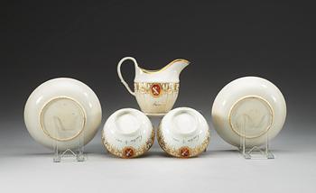Two armorial tea cups with saucers and a creamer, Qing dynasty, Jiaqing (1796-1820).