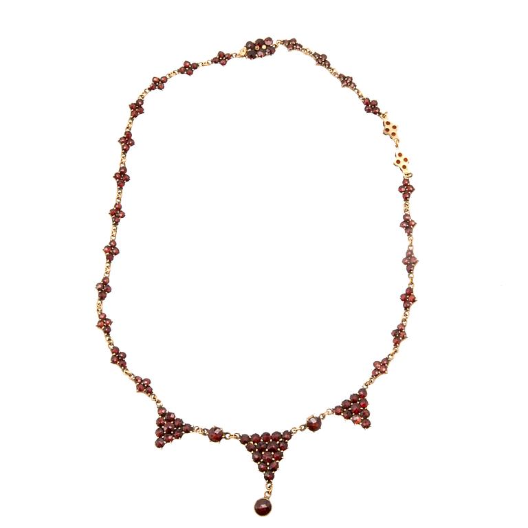 Necklace, earrings, and brooch with faceted garnets.