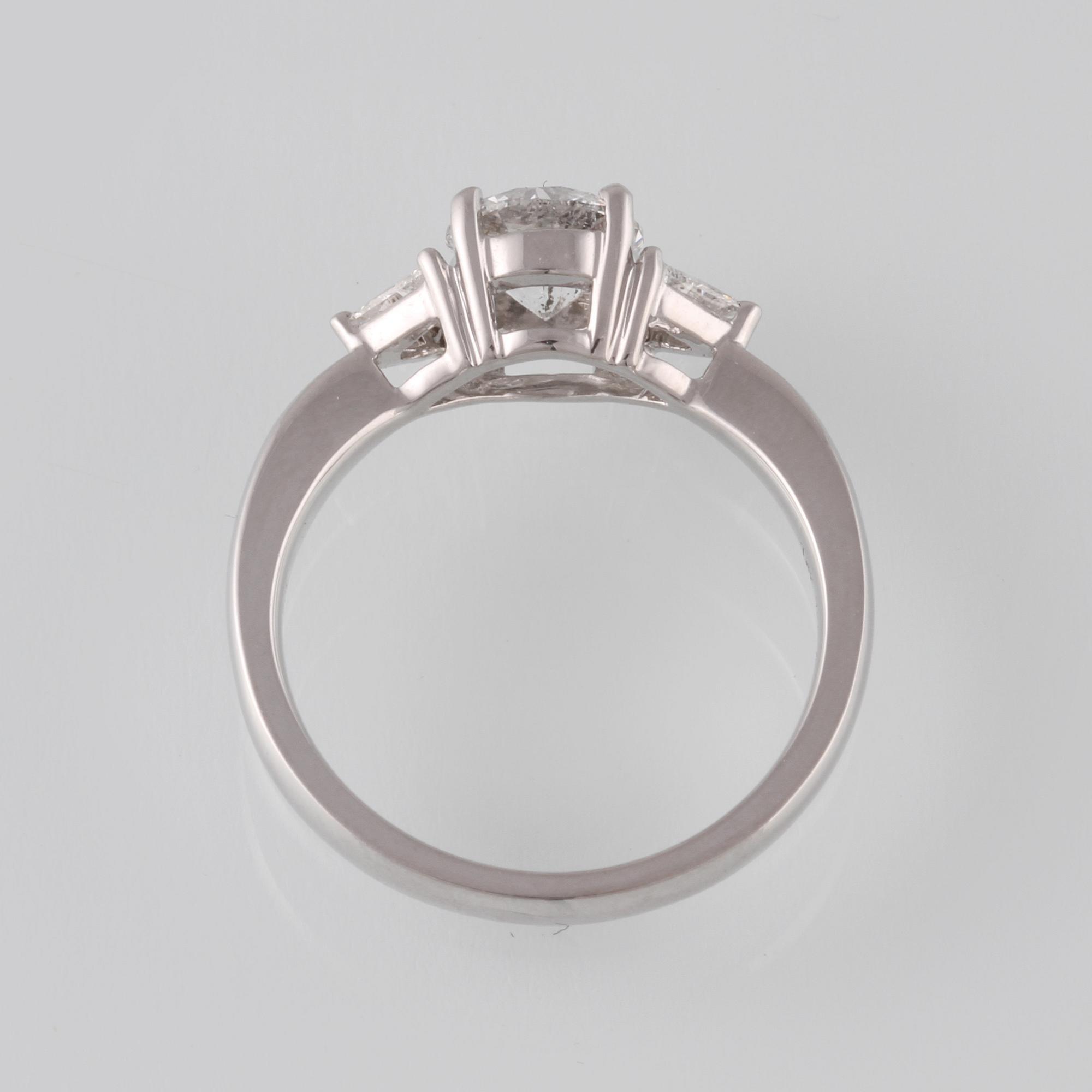RING, 18K vitguld med briljantslipad diamant 1.03 ct samt 2 triangelslipade diamanter 0.17 ct. Vikt 4,4 gram.