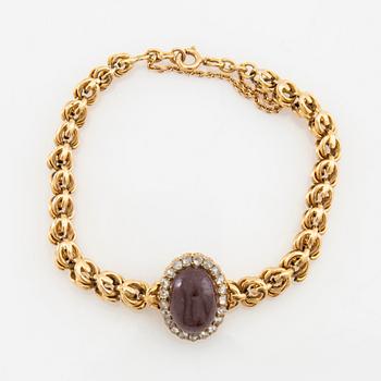 Bracelet in 18K gold set with rose-cut diamonds and an oval cabochon-cut garnet.
