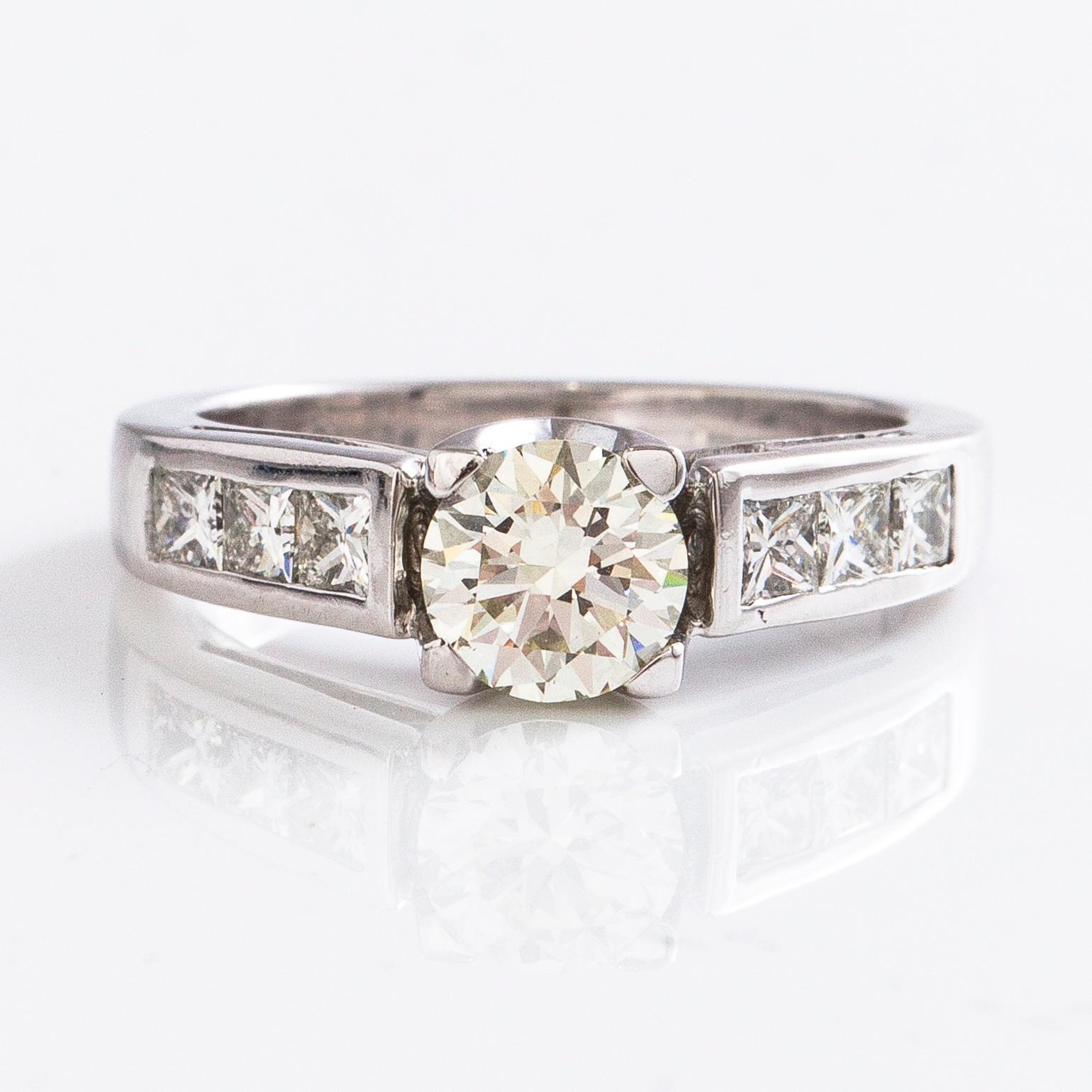 An 18K gold ring with a brilliant-cut diamond ca. 1 ct and princess-cut diamonds ca. 0.7 ct in total.