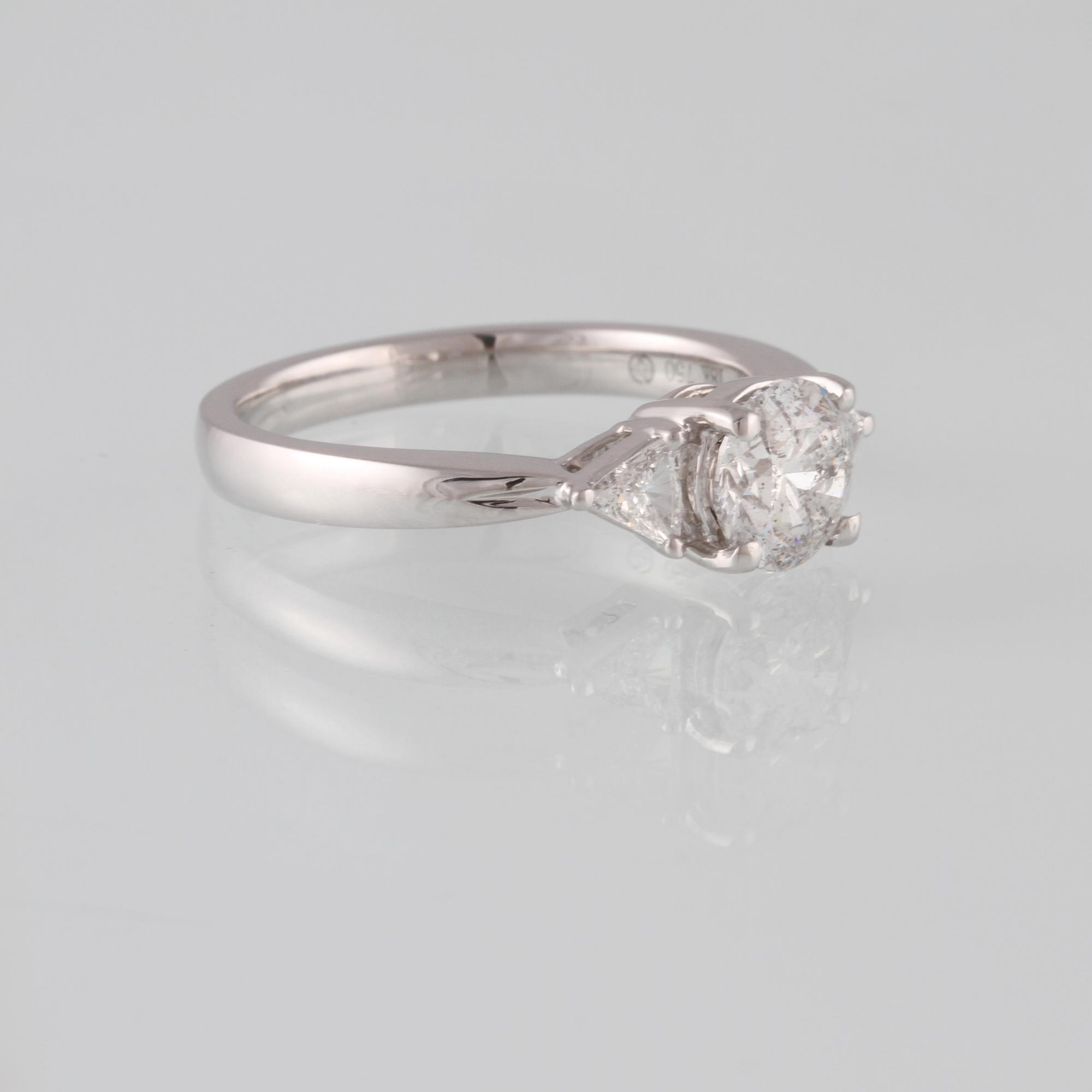 RING, 18K vitguld med briljantslipad diamant 1.03 ct samt 2 triangelslipade diamanter 0.17 ct. Vikt 4,4 gram.