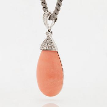 An 18K white gold and coral pendant set with round brilliant-cut diamonds.