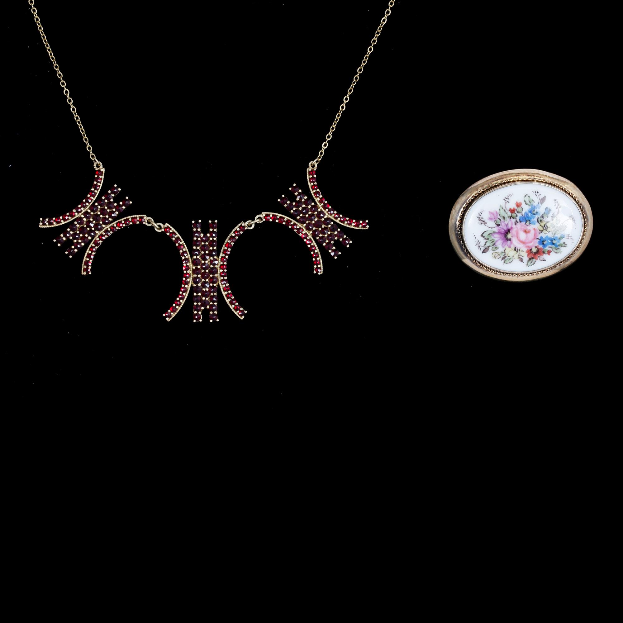 HALSSMYCKE OCH BROSCH, förgyllt silver med granater resp målat porslin. Brosch Finland, 1951.