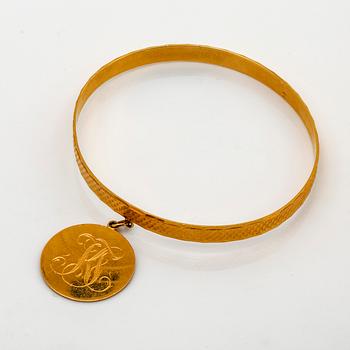 Bangle 18k gold with 1 charm, 19,3 g, does not open.