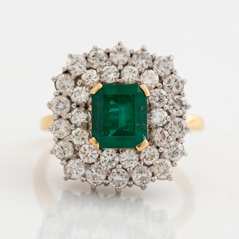 Ring, 18K guld, smaragdslipad smaragd ca 2 ct, med 32 briljantslipade diamanter totalt ca 2 ct.