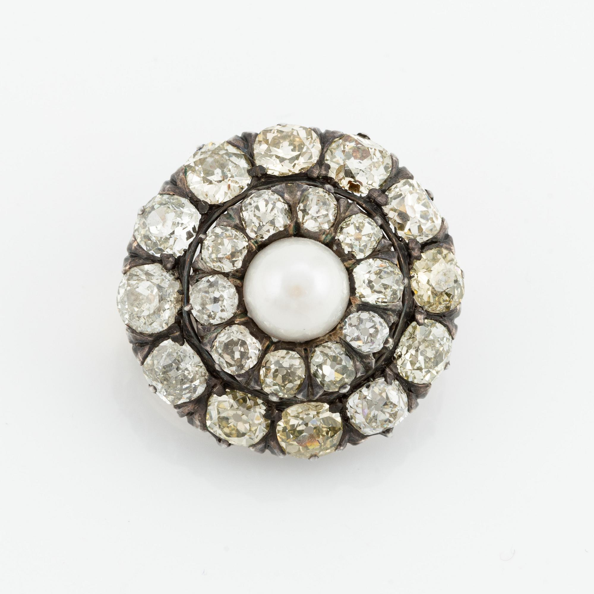 A silver and gold brooch, with cushion-cut diamonds and a pearl.