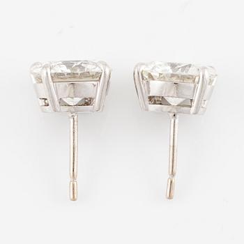 A pair of earrings in 18K white gold set with two round brilliant-cut diamonds.