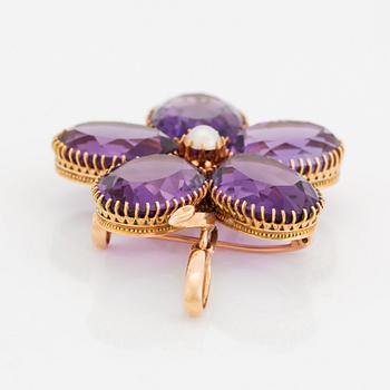 An 18K gold brooch/pendant set with faceted amethysts and a pearl.