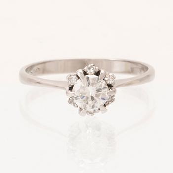 An 18K white gold ring set with a round brilliant cut diamond and single cut diamonds.