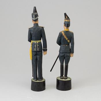 Two wooden sculptures depicting Swedish officers, signed and daterd 1939.