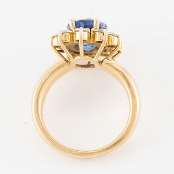 Ring 18K guld med en fasettslipad safir och runda briljantslipade diamanter.