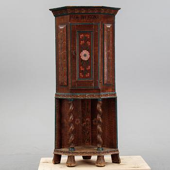 A painted corner cabinet, dated 1778.