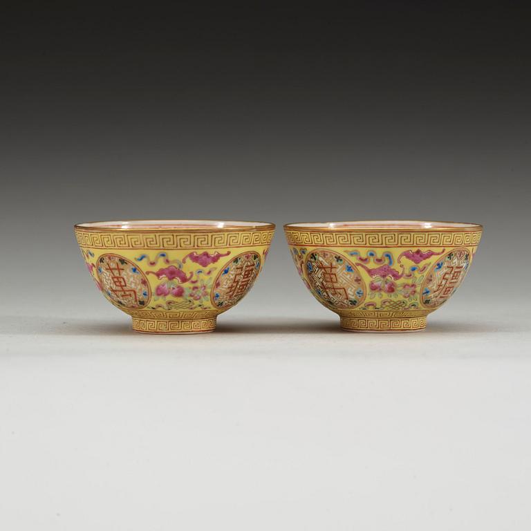 A pair of famille rose yellow ground cups, Qing dynasty, Guangxu six-character mark and of the period  (1875-1908).