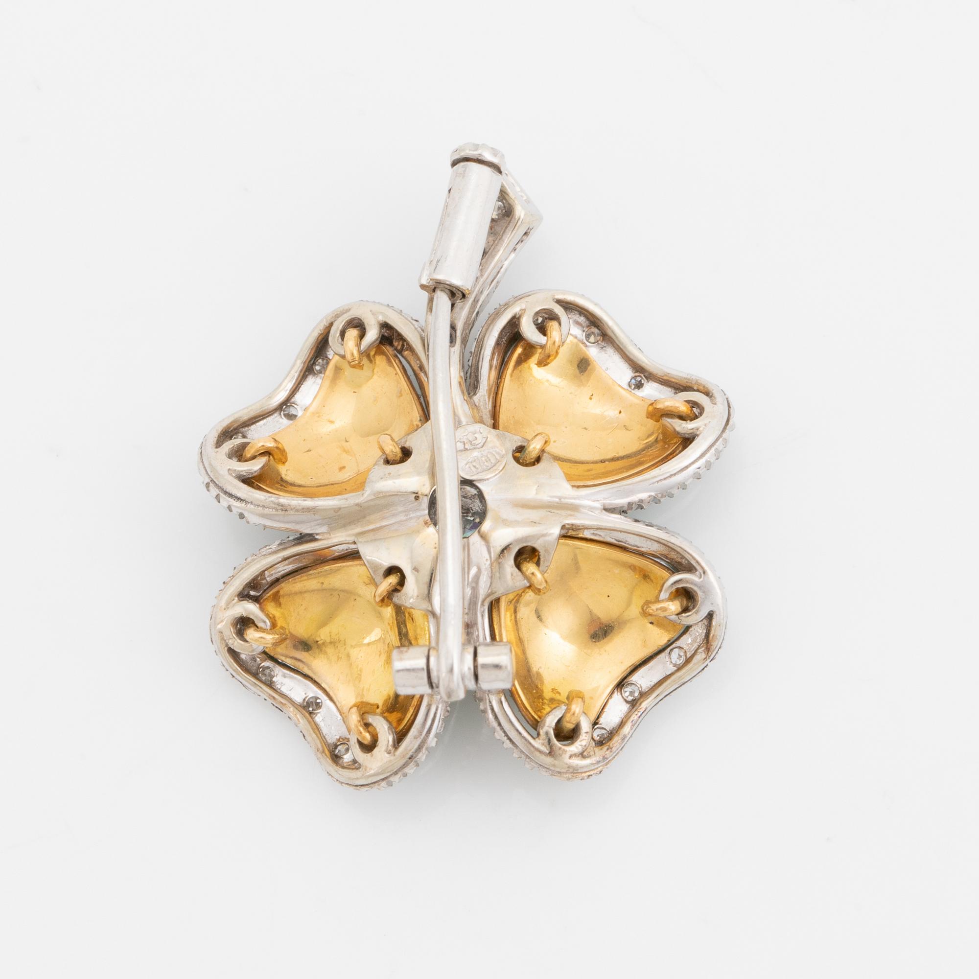 An 18K gold and enamel brooch set with round brilliant-cut diamonds.