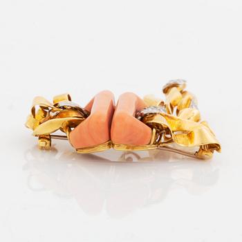 A Kutchinsky brooch in 18K gold set with coral and round brilliant-cut diamonds.