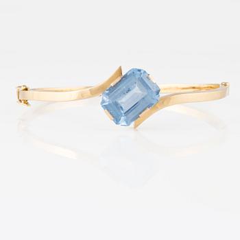 ARMRING, 18K guld med fasettslipad syntetisk blå spinell, Svenskt Guldsmide, Stockholm, 1956. Vikt 9,8 gram.
